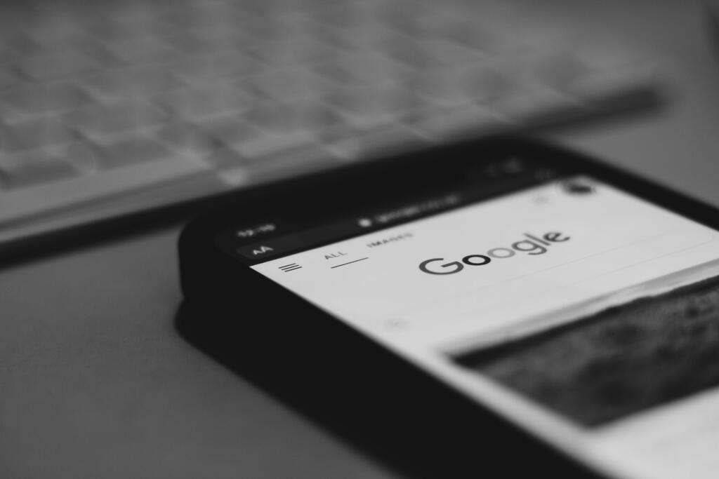Mobile phone displaying Google search results on a desk.